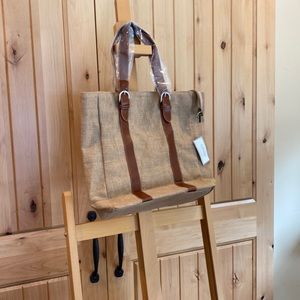 Taleen burlap tote bag with belted vinyl straps.